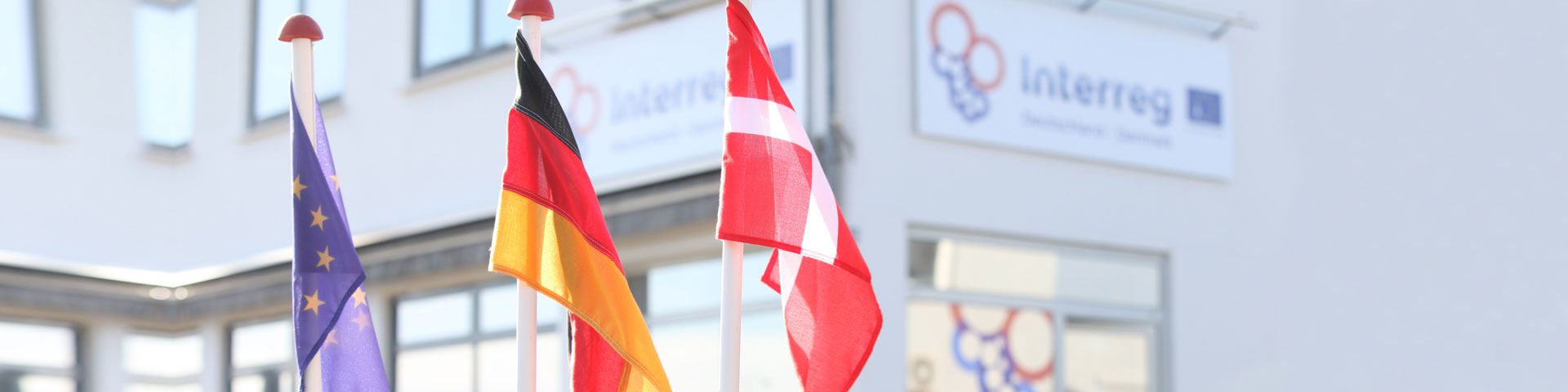 Vor dem Interreg-Gebäude wehen die europäische, deutsche und dänische Flagge 